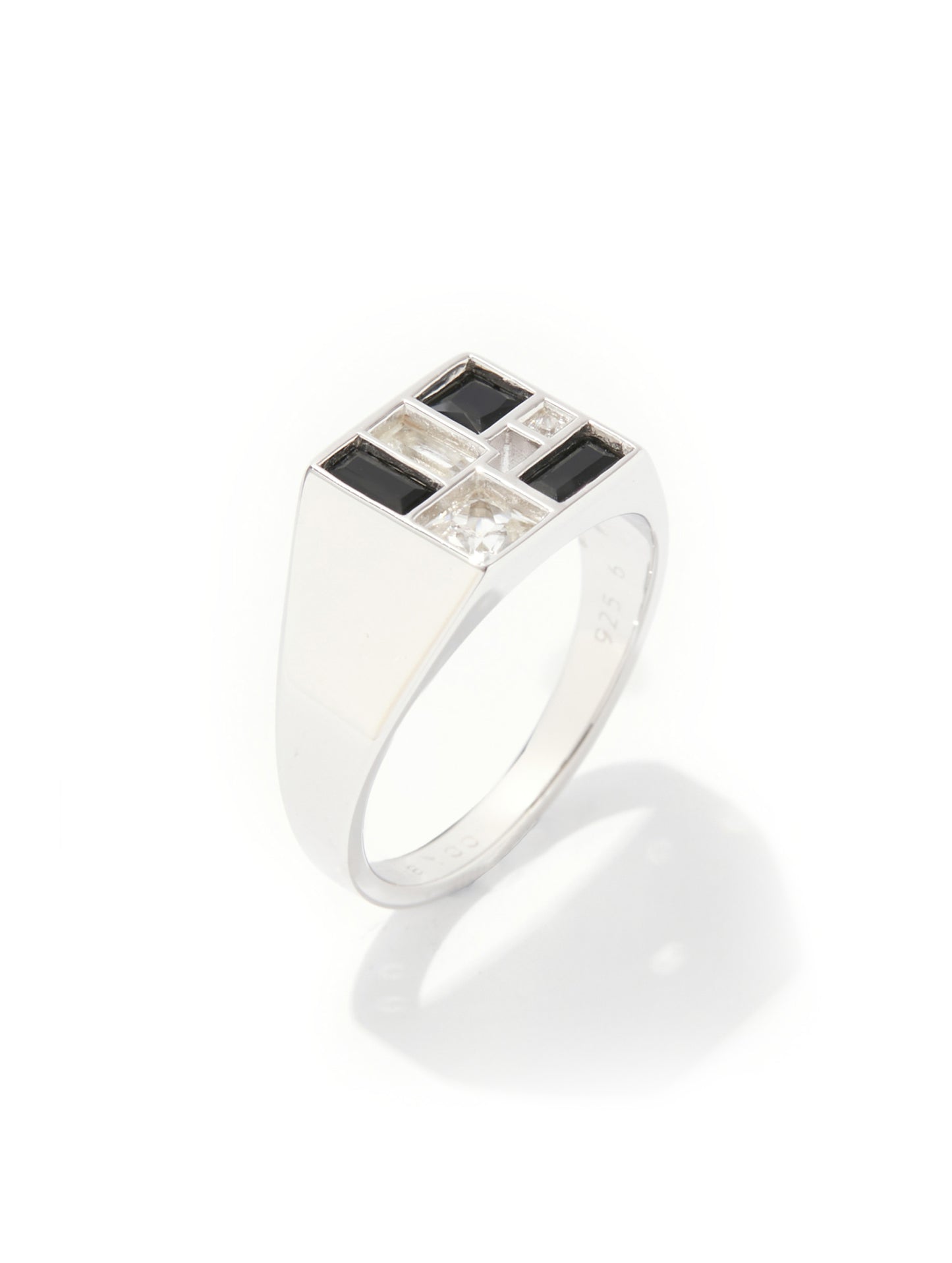 A silver signet ring featuring a square face with alternating black and clear rectangular stones, set against a clean white background with a soft shadow.