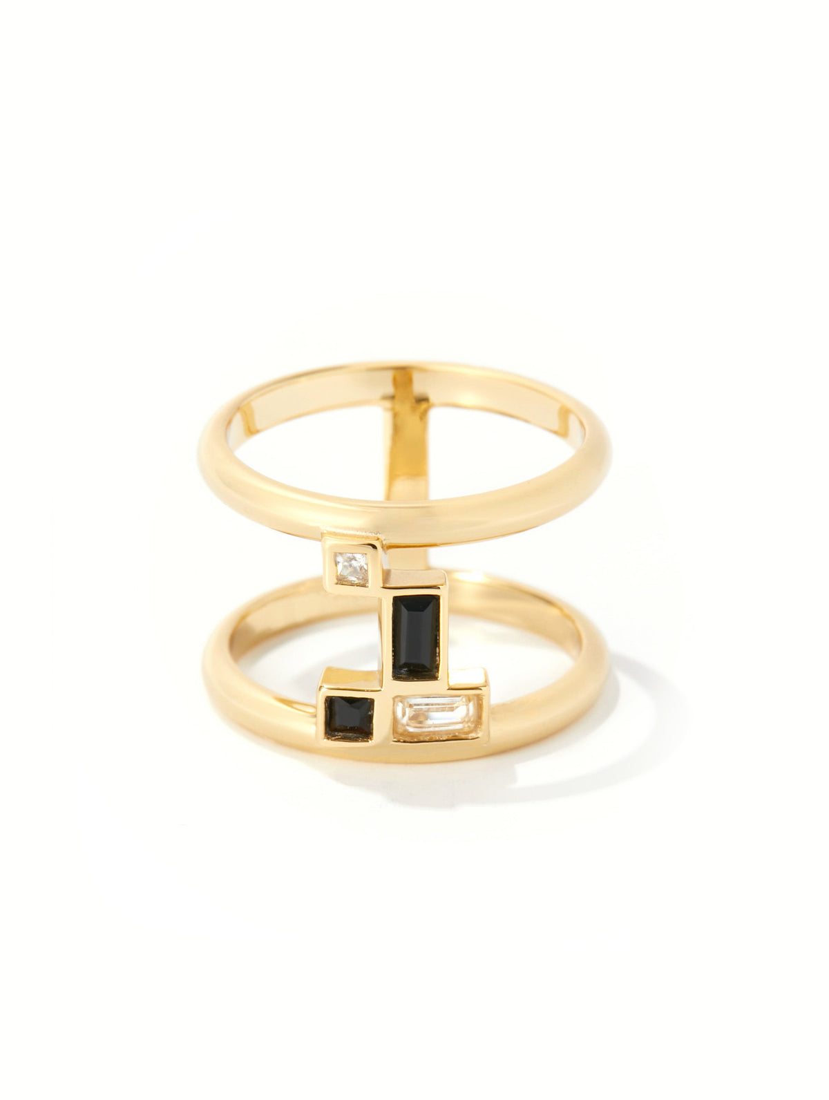 A gold geometric ring with stacked bands and rectangular black and clear gemstone accents, photographed on a clean white background.