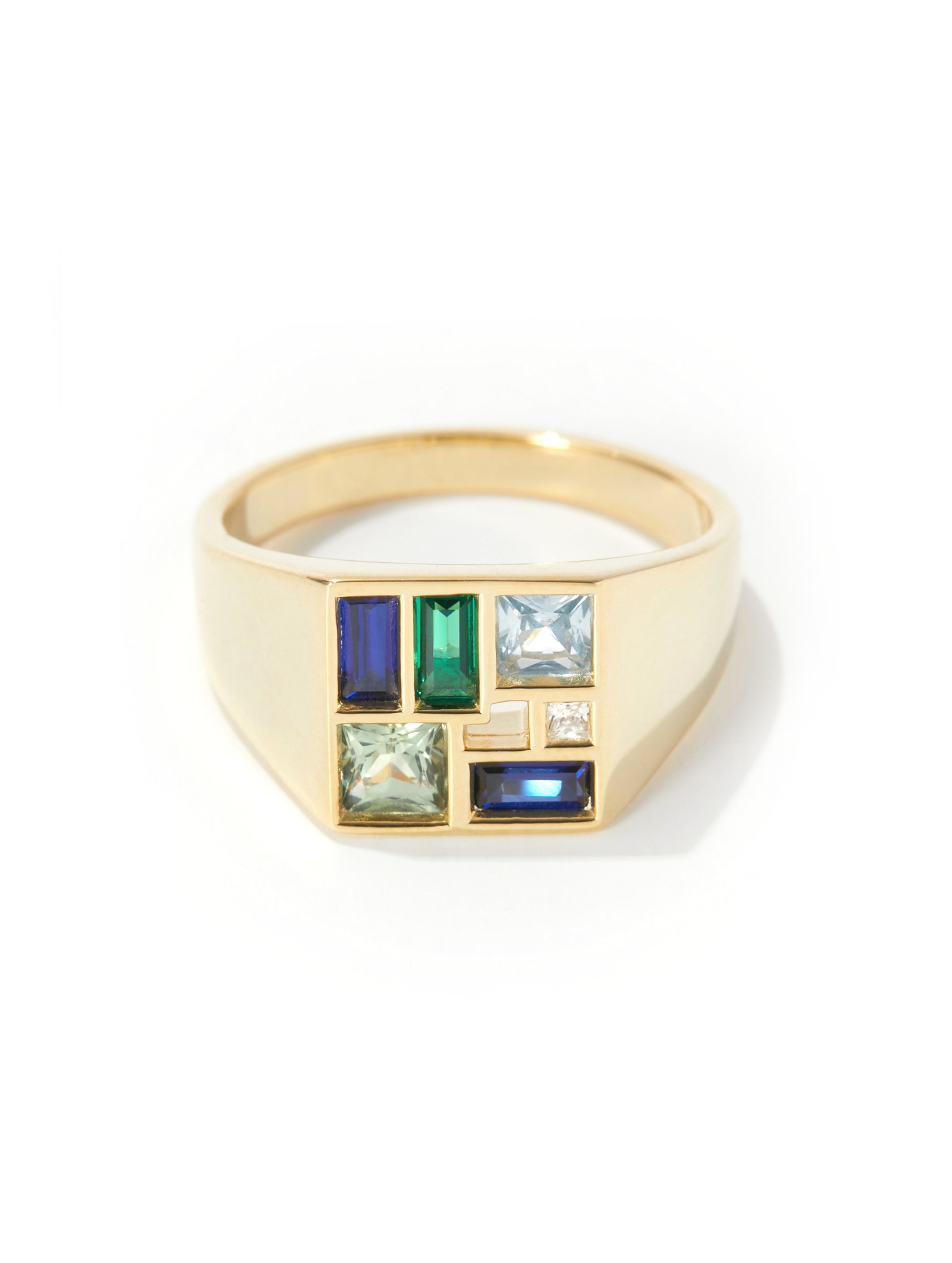 A gold signet ring featuring a geometric face with multiple colored gemstones, including blue, green, and light blue stones, set against a clean white background.