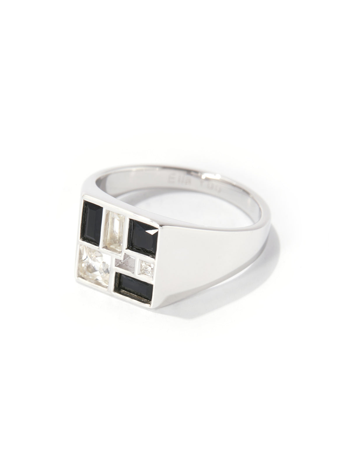 A silver signet ring featuring a geometric face with alternating black and clear rectangular stones, set against a plain white background.
