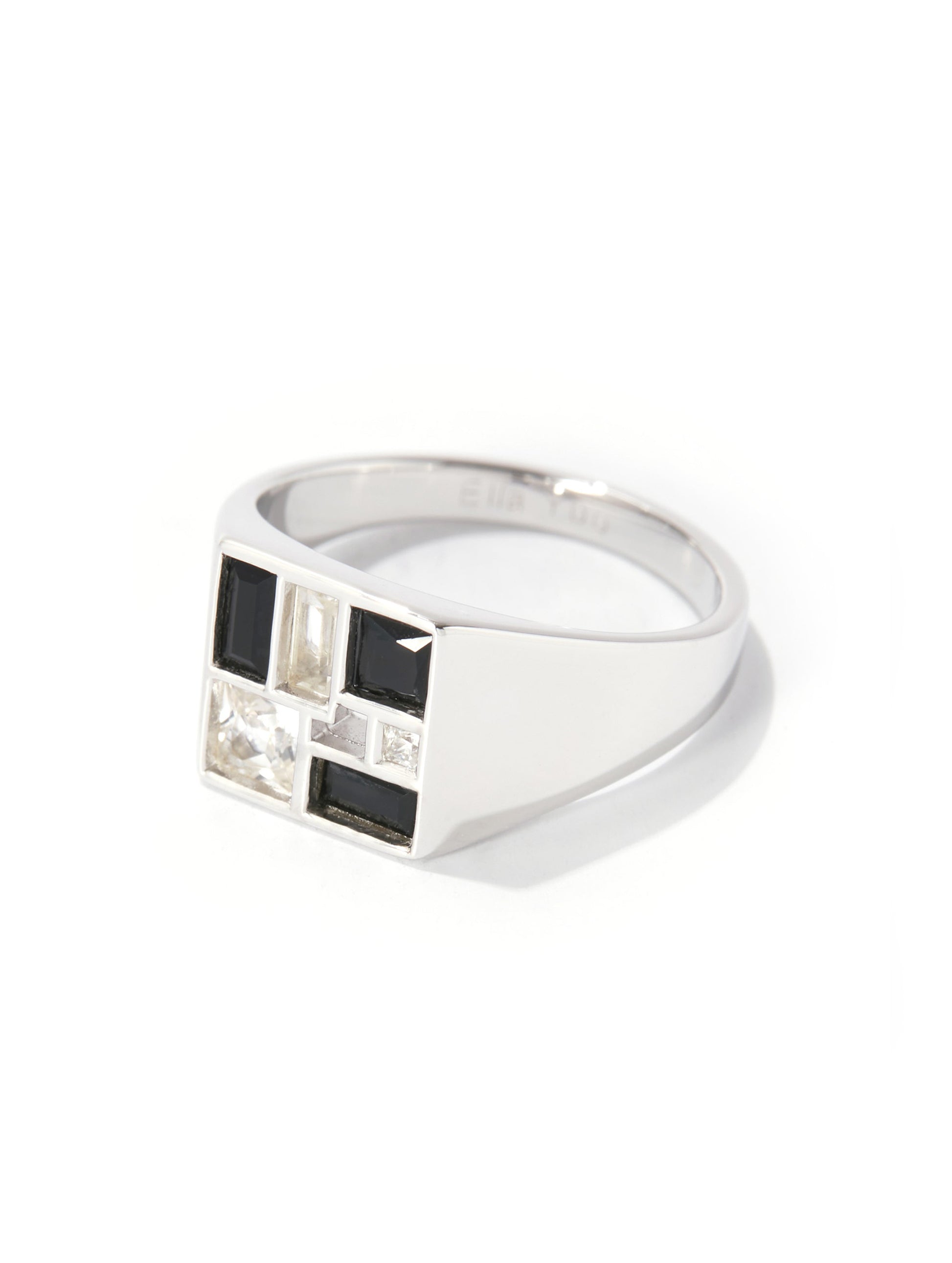 A silver-toned geometric signet ring featuring a front panel with alternating black and clear rectangular stones, set against a plain white background.