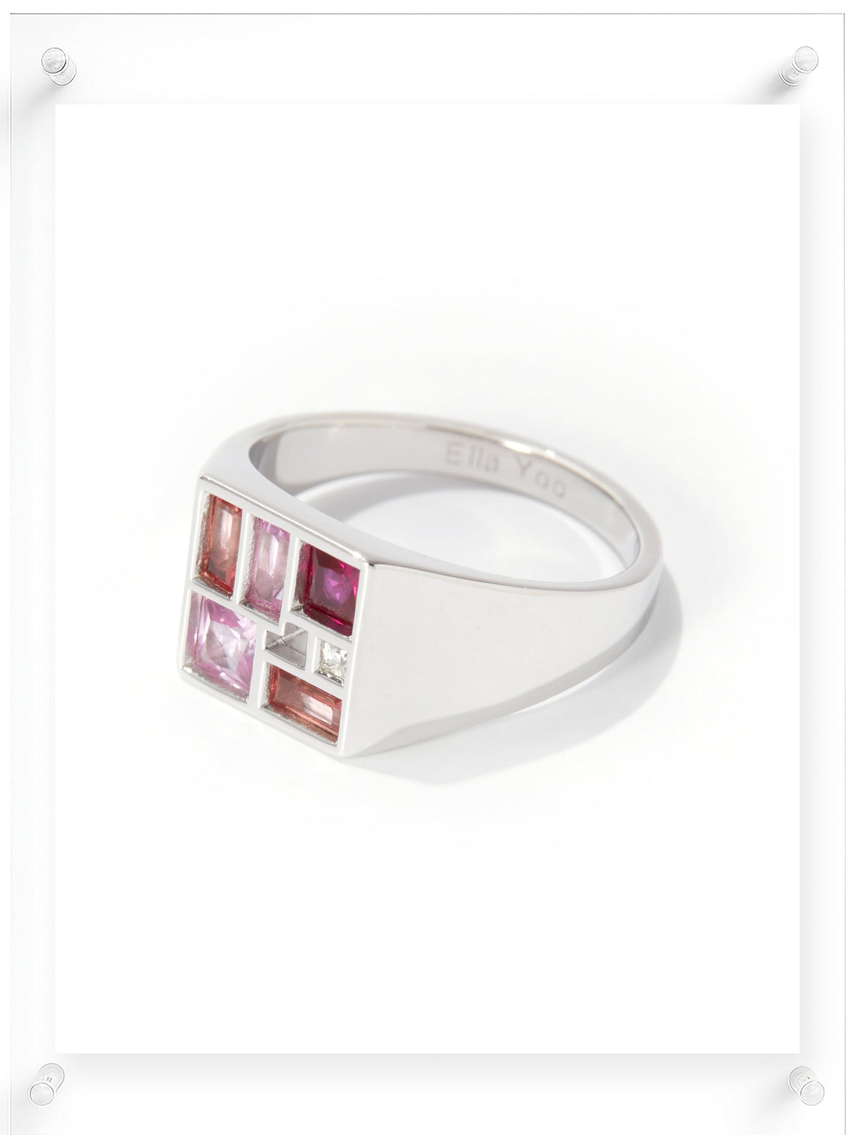 Silver ring with pink gemstones on a white background