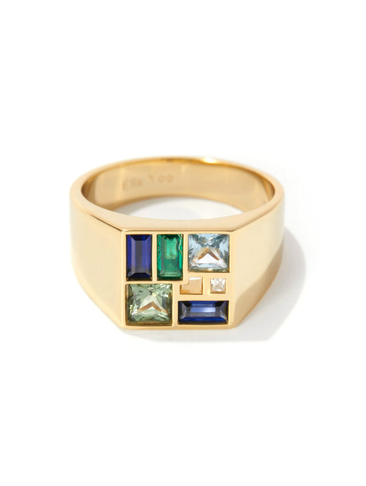 A gold signet ring featuring a geometric face with multiple rectangular gemstones in blue, green, and light gray, set against a clean white background.