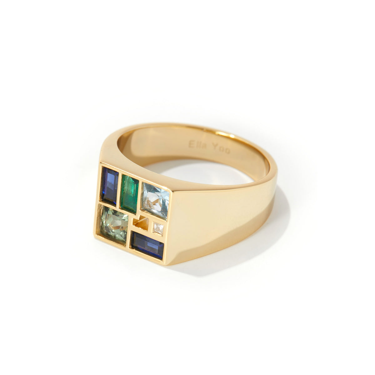 A gold signet ring with a grid of colored gemstones, including blue, green, and light blue stones, on a clean white background.
