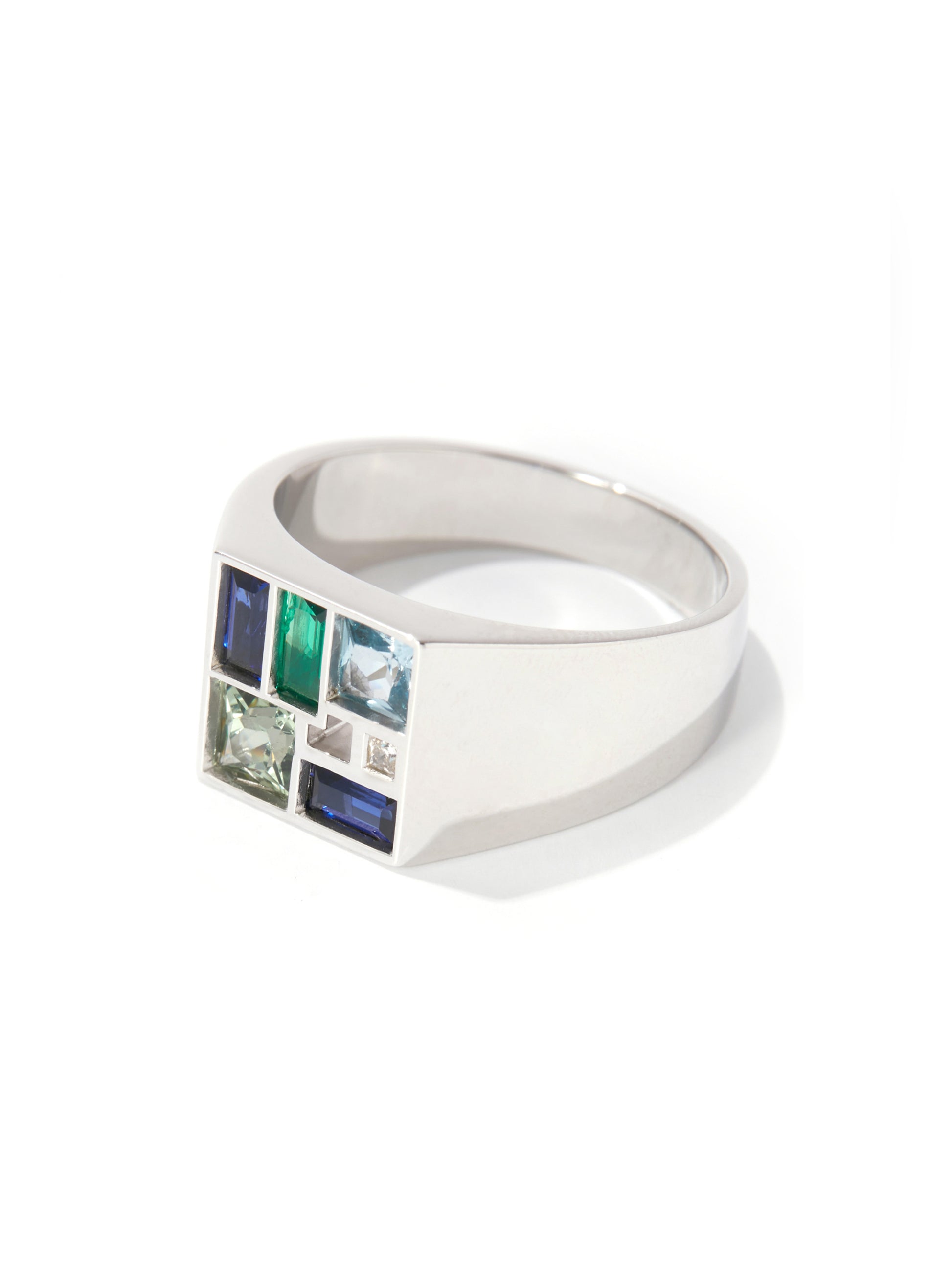 A silver-toned signet ring featuring a grid of small inset gemstones in blue, green, and clear, set against a clean white background.