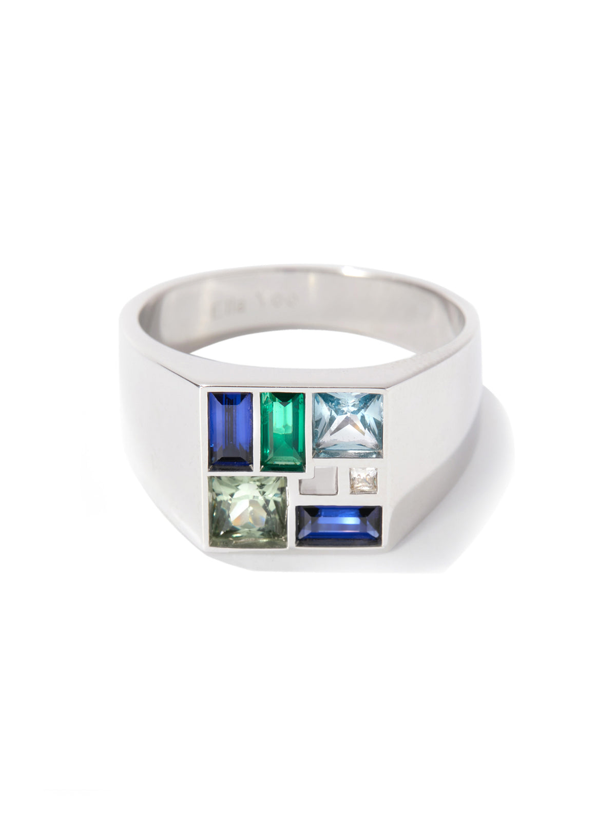 A silver-toned geometric ring featuring a grid of colorful rectangular gemstones in blue, green, and light blue, set against a clean white background.
