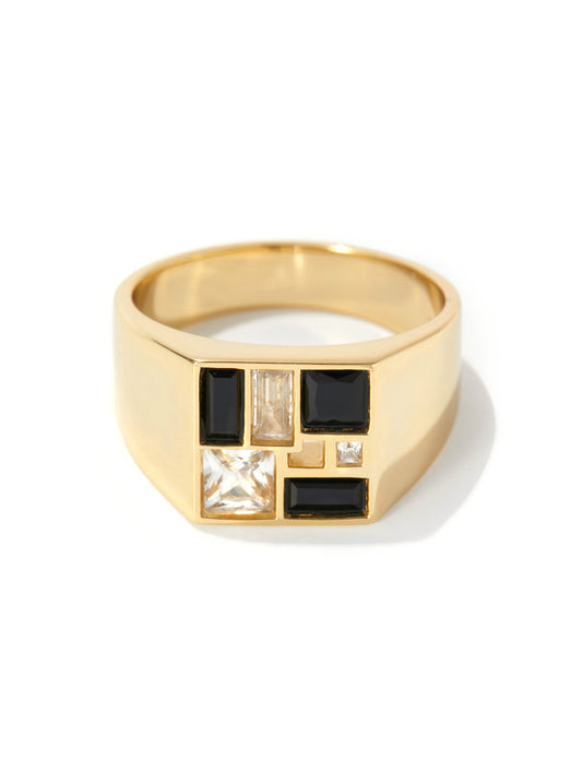 A gold signet ring featuring a geometric face with black rectangular inlays, a square clear crystal, and a vertical clear baguette crystal, set against a plain white background.
