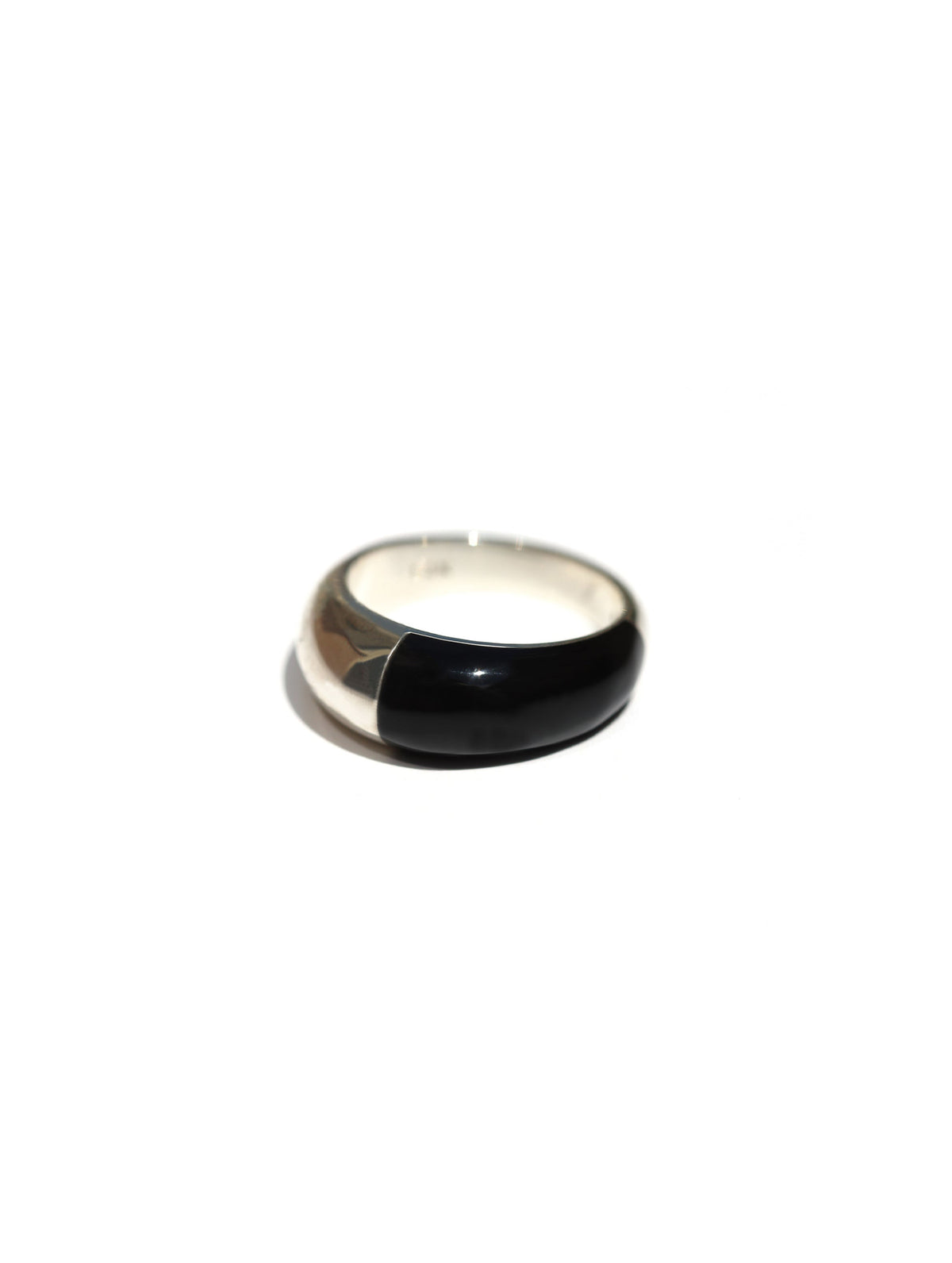 A minimalist split-design ring with a polished silver-tone band and a half-black enamel inlay, shown on a plain white background.