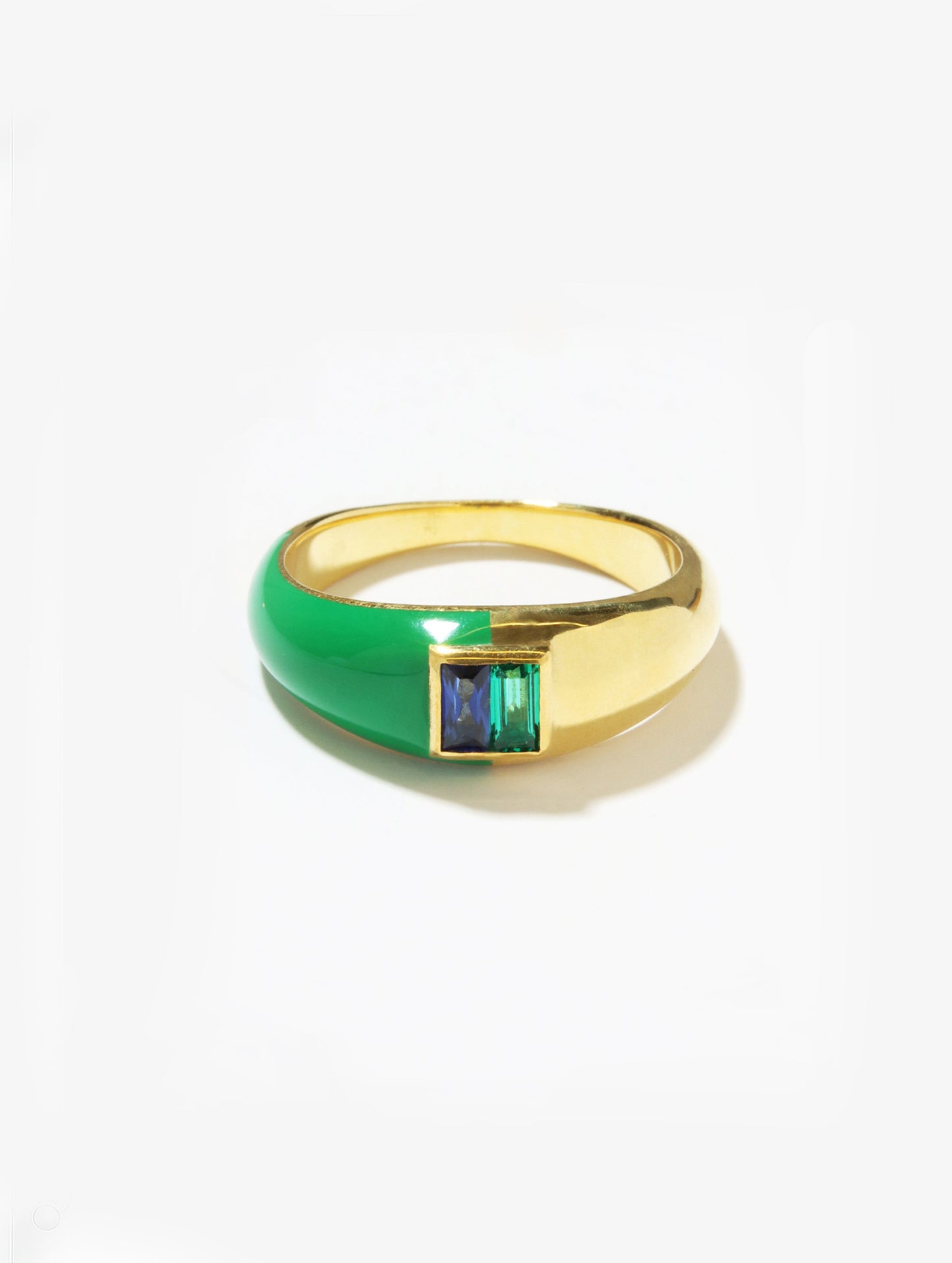 A gold ring with a smooth green enamel half-band and a square bezel setting featuring a blue and green striped stone, photographed on a clean white background.