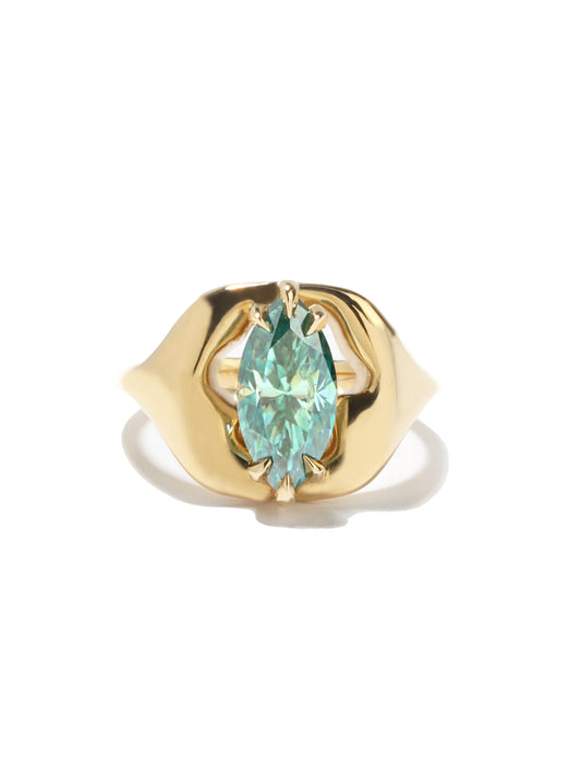 A gold ring featuring a marquise-cut light blue gemstone in a prong setting, set against a clean white background with a soft shadow.